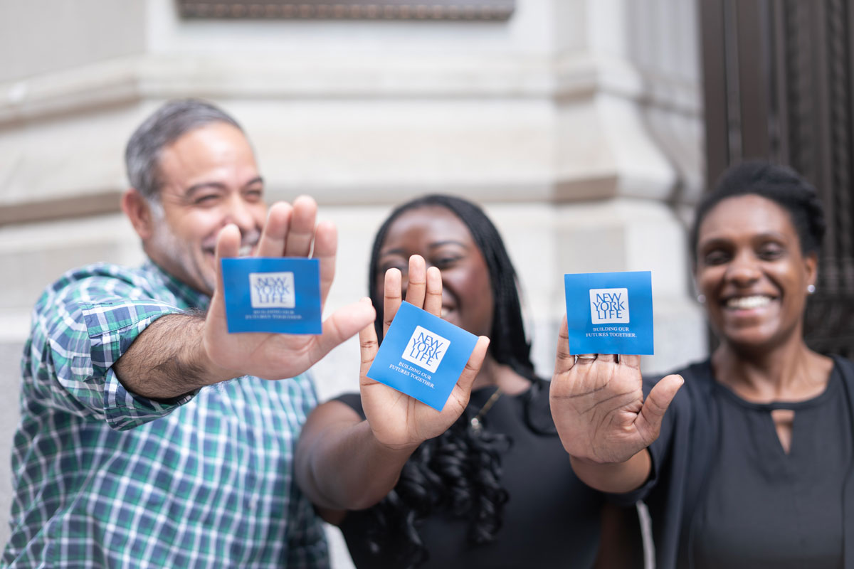 New York Life team members holding company cards during a corporate photo session